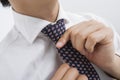 Midsection of mid adult businessman adjusting tie