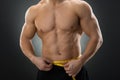 Midsection Of Muscular Man Measuring Waist Royalty Free Stock Photo