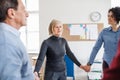 Midsection of people standing in a circle and holding hands during group therapy. Royalty Free Stock Photo