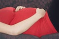 Midsection Of Pregnant Woman Relaxing On Sofa