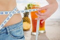 Midsection section of woman measuring waist with juices in background Royalty Free Stock Photo