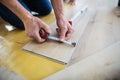 A midsection of senior man laying vinyl flooring, a new home concept.