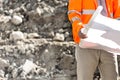 Midsection of supervisor holding blueprint at construction site Royalty Free Stock Photo