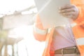 Midsection supervisor holding clipboard at construction site on sunny day Royalty Free Stock Photo