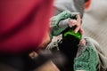 A midsection view of homeless beggar man sitting outdoors, holding bottle of alcohol.