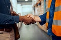 Midsection view of two male workers shaking hands at factory Royalty Free Stock Photo