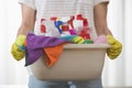 Midsection of woman carrying basket of cleaning supplies