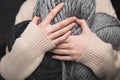 Midsection of woman holding grey yarn balls in hands