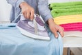 Midsection of woman ironing shirt