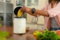 Midsection of young african american woman putting banana peel in compost bin at home Royalty Free Stock Photo