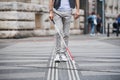 Midsection of young blind man with white cane walking across the street in city.