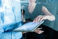 Midsection of young businesspeople with tablet in an office, working. Royalty Free Stock Photo