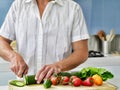 Midsection of young man cutting vegetables on wooden board in domestic kitchen Royalty Free Stock Photo