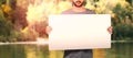 Composite image of midsection of young man holding cardboard