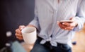 A midsection of young woman with coffee and smartphone. A startup of small business.