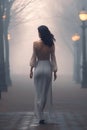 pretty fashion woman wearing a long white dress and wavy long black hair walking away.