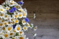 Midsummer bouquet of summer flowers white daisies and blue cornflowers in the vase on wooden background with copy space. Royalty Free Stock Photo