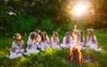 Midsummer. Group of young people of Slavic appearance are sitting around a campfire.
