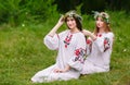 Midsummer. Two girls in the Slavic clothes weave braids in the hair near the fire Royalty Free Stock Photo