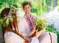 Midsummer. Young loving couple in Slavic costumes on the shore of the lake. Slavonic holiday of Ivan Kupala.