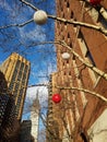 Midtown holiday cityscape. Ornaments on tree branches below Empire State Building