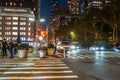 Midtown Manhattan street scene viewed at night with people, cars and buildings