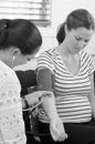 Midwife checks pregnant woman blood pressure Royalty Free Stock Photo