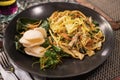 Mie goreng, a traditional balinese food served during the dinner in a black plate in a restaurant in Bali