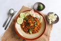 mie tek tek or fried noodle made with egg noodles with chicken, cabbage, mustard greens, meatballs, scrambled eggs. indonesian. Royalty Free Stock Photo