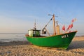Miedzyzdroje, Poland, November 2018: Green fishing boat on the sandy beach on the Baltic Sea