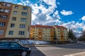 Renewed apartment buildings near road, passing cars.