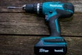 Makita cordless drill on aged pine wood boards.