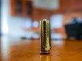 Footmark alkaline batteries on wooden table with shallow depth of field.