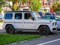 Side view of a parking white Mercedes Benz G 63 in the city.