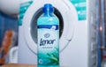 Lenor fabric conditioner in front of a laundry washing machine.