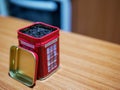 Iconic british souvenir tin telephone booth filled with afternoon tea on the table. Royalty Free Stock Photo