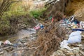 Cleen little creek contaminated with household waste, conceptual human negligence image.