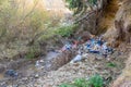 Cleen little creek contaminated with household waste, conceptual human negligence image.