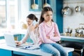 Miffed little girl sitting on the table