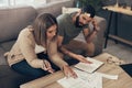 It might be time for some debt relief. a young couple looking stressed while going over paperwork at home.