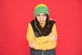 It might be too cold to trek outside. Little child feel cold red background. Small girl shiver in cold weather wear