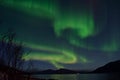 Mighty aurora borealis dancing on night sky over mountain and fjord landscape in late autumn Royalty Free Stock Photo