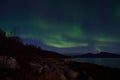 Mighty aurora borealis dancing on night sky over mountain and fjord landscape in late autumn Royalty Free Stock Photo