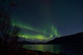 Mighty aurora borealis dancing on night sky over mountain and fjord landscape in late autumn Royalty Free Stock Photo