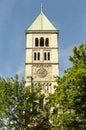 Mighty bell tower with large clock face and statue of the Virgin Mary of the Holy Spirit Church, a Neo-Romanesque basilica in the