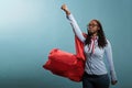 Mighty and brave african american superhero woman posing as justice defender while acting like flying on blue background