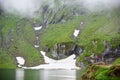 Mighty mountains are covered fog and lake at foot, Romania Royalty Free Stock Photo