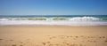 Mighty strong waves roar as they constantly crash onto sandy beach empty with copy space.