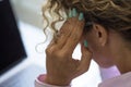 Migraine headache unhealthy stress problems people at work in front of a computer. Back view closeup of woman working on laptop Royalty Free Stock Photo