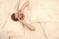 Migraine headaches. Handsome man relaxing in bed. Snoring can increase risk headaches. Common symptom of sleep apnea